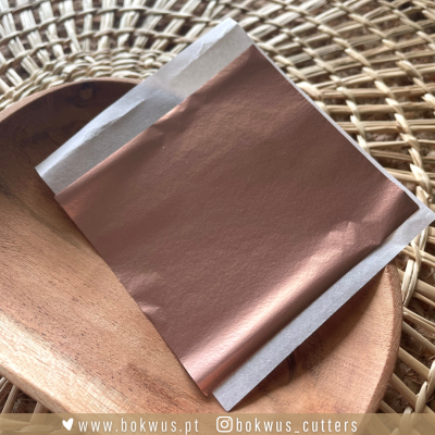 Pacote cobre metálico com bordas brancas em bandeja de madeira sobre ratoeira