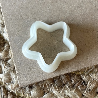 Cortador de biscoitos branco em forma de estrela sobre fundo castanho e fibra natural