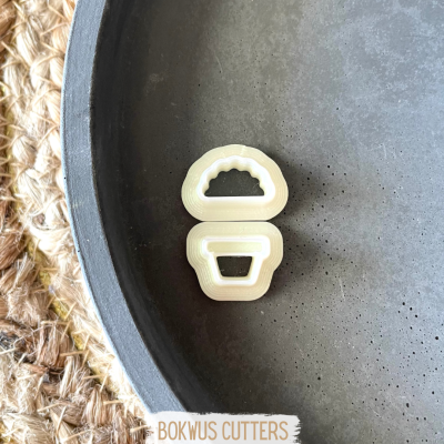 Dois cortadores de balde em plástico crema numa superfície cinza redonda