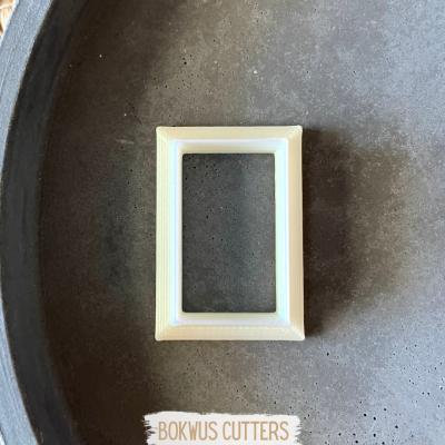 Cortador de bolachas retangular branco sobre superfície cinzenta com crachá BOKWUS CUTTERS