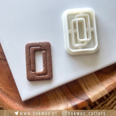 Cortantes retangulares para massa em branco e castanho com pontos brancos sobre superfície branca e madeira