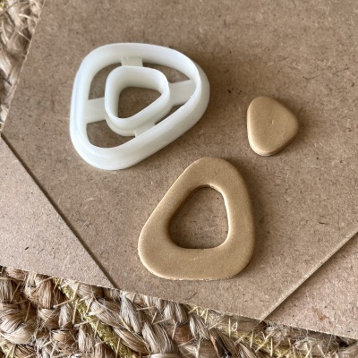 Três botões triangulares dourados e branco sobre cartão e base de corda trançada