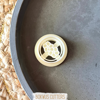 Cortante plástico em forma de cacho de uvas sobre prato cinzento