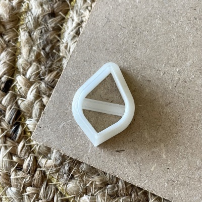 Peça plástica branca com forma geométrica em cartão e tapete de fibra