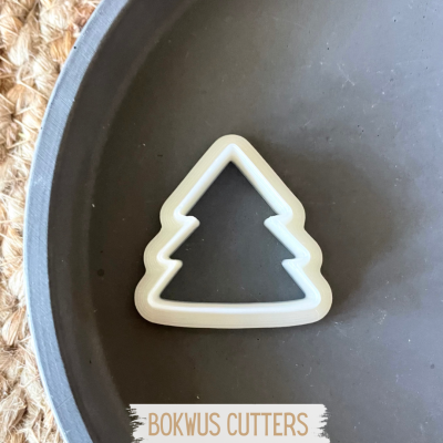 Forma de cookie em forma de árvore de Natal branca numa bandeja cinzenta