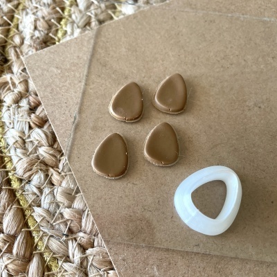 Botões castanhos e branco sobre fundos marrons e tecido entrelaçado