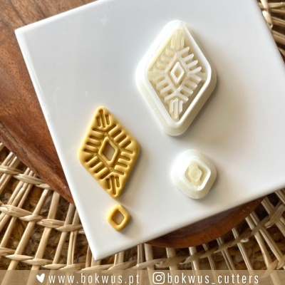 Conjunto de cortadores geométricos em plástico sobre prato branco e superfície de madeira