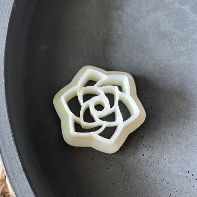 Porta-guardanapo branco em forma de flor numa tigela preta