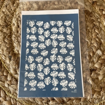 Stencil azul com padrão de folhas brancas sobre fundo trançado