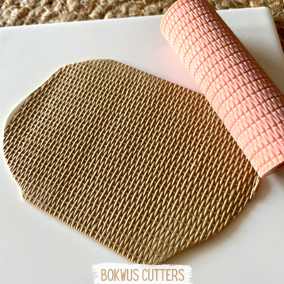 Manta texturizada bege e rosa para porcelana fria com padrão quadriculado.