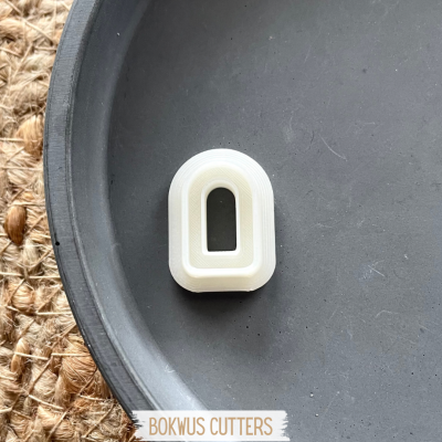 Cortante branco de plástico em prato cinza com esteira de fibras ao fundo