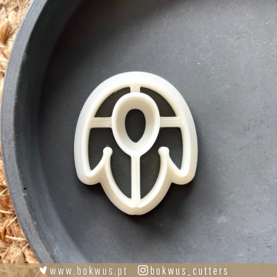 Cortador de bolachas em plástico branco com padrão de pétalas e folha em prato preto