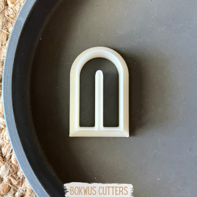 Cortador de massa branco em forma de arco numa superfície preta com texto BOKWUS CUTTERS