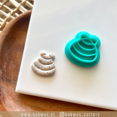 Molde de plástico azul e peça moldada bege com manchas em superfície branca