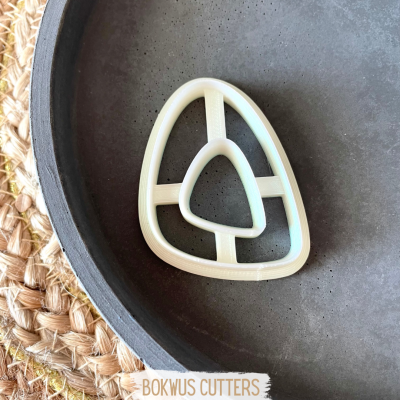 Forma de cortar biscoitos ou pão em plástico branco com design geométrico numa travessa cinzenta