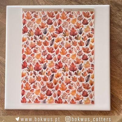 Azulejo branco com padrão de folhas castanhas e laranjas