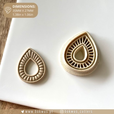 Cortante ou carimbo de massa bege em forma de gota detalhado sobre superfície branca