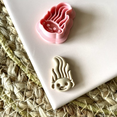 Molde de cortar biscoitos e biscoito com formato de rosto sorridente com cabelo esvoaçante