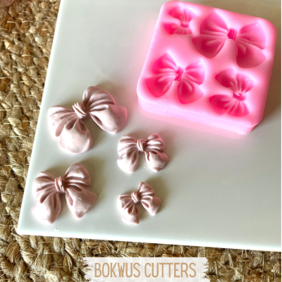 Moldes rosa de silicone com laços e laços cor-de-rosa feitos em pasta de açúcar