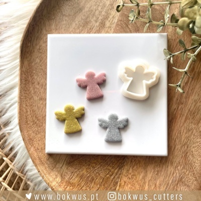 Cortadores de biscoitos em forma de anjo em azulejo branco com base de madeira