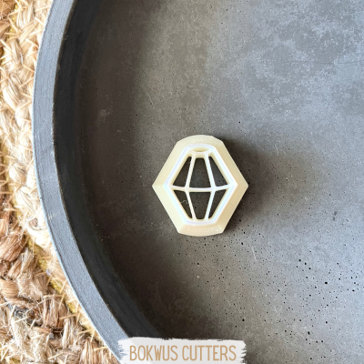 Cortador branco hexagonal com padrão interno em prato cinzento