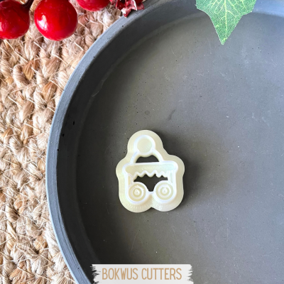 Cortador de biscoitos em plástico bege em forma de carrinho sobre prato cinza