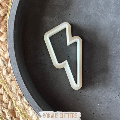 cortador de bolachas em forma de raio branco num prato cinzento