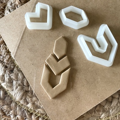 Cortadores geométricos de plástico e peça de massa moldada sobre cartão e tapete de fibras naturais