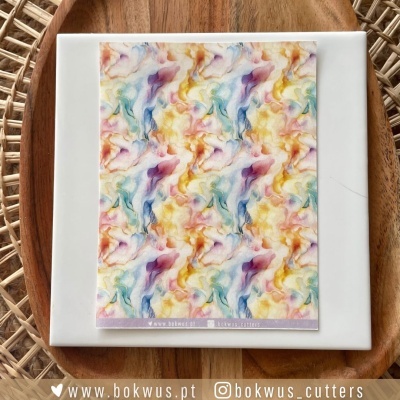 Cartão com padrão abstrato colorido sobre prato branco em prato de madeira e fundo em fibra trançada