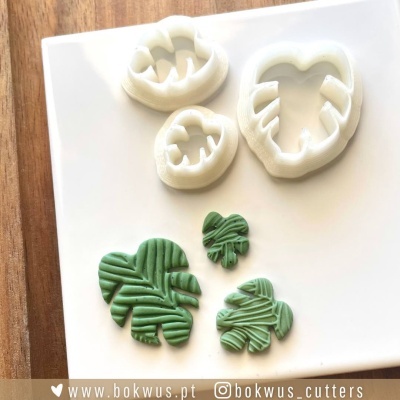 Conjunto de cortadores de massa em formato de folhas tropicais com peças de massa verde moldadas