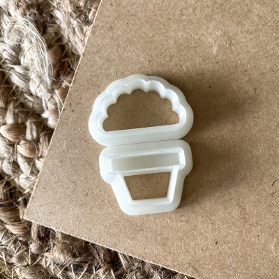 Cortador de bolachas em forma de vaso de plantas branco sobre cartão castanho