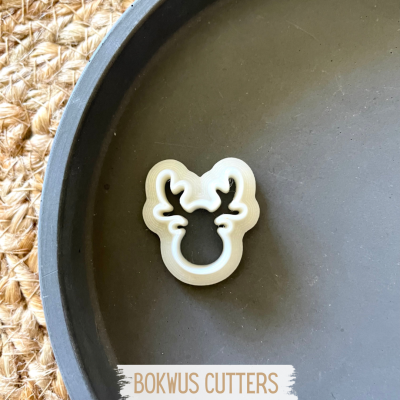 Cortante formato rena branco sobre prato preto com fundo de ráfia e texto BOKWUS CUTTERS