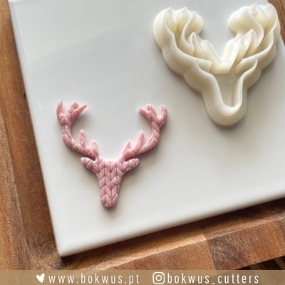 Figuras decorativas de cabeça de veado em rosa e branco com texturas sobre placa branca