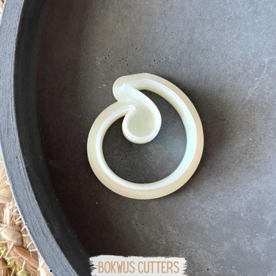 Cortante de massa circular com design em espiral branco numa superfície cinza