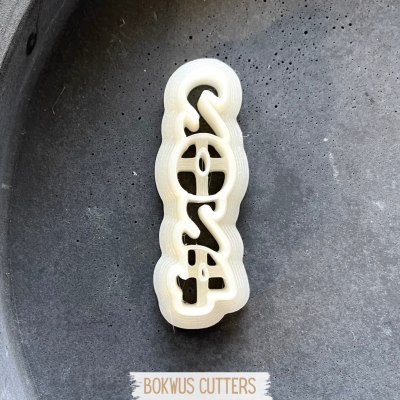 Cortador de bolachas branco com design da palavra COSA sobre fundo cinzento