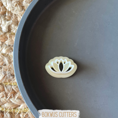 Cortador de massa em forma de flor de lótus, plástico creme, dentro de prato cinza