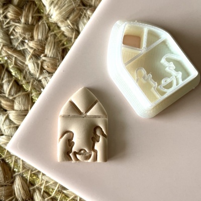 Dois objetos em forma de janela com relevo, cores bege claro e branco, sobre superfície rosa e tapete de fibras naturais