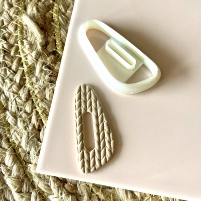 Ganchos para cabelo bege e branco sobre superfície creme e tecido de fibras naturais