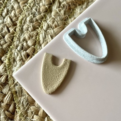 Dois pentes de unha cerâmicos sobre base branca e superfície de tecido trançado