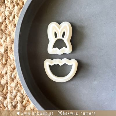 Dois cortadores de biscoitos brancos em formato de ovo partido e cabeça de coelho