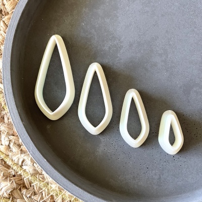 Quatro cortadores de massa em plástico formato gota em tigela cinza