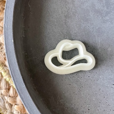 Forma de massa branca em forma de chapéu de cowboy numa travessa cinza escura texturizada