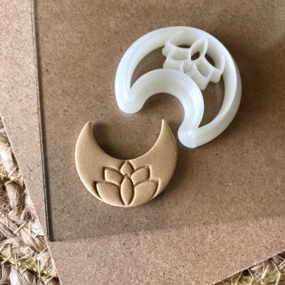 Cortador de biscoitos branco e biscoito castanho com formato de meia-lua e design de flor de lótus