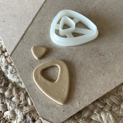 Peças triangulares de argila bege com molde branco plástico.