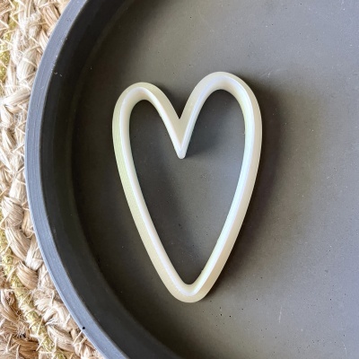 Forma de bolachas em coração branca sobre placa cinzenta