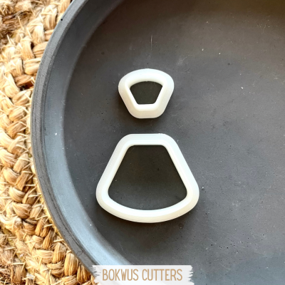 Dois cortadores de massa em plástico branco sobre prato cinzento