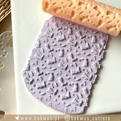 Rolo de textura com padrões de ossos e patas de cães a imprimir em massa lilás