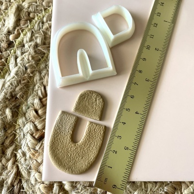 moldes de silicone e peças de argila com régua sobre superfície rosa clara