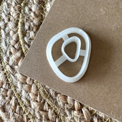 Forma de corte para bolachas em plástico branco sobre cartão e tapete de fibras naturais