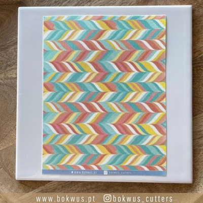 Quadrado com padrão colorido de folhas em diagonal e texto inferior